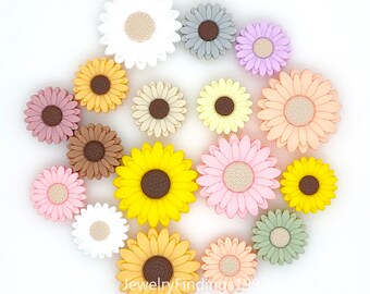 May include: Assortment of 15 colorful silicone flower charms in various colors, including yellow, pink, white, brown, gray, and peach. The flowers have a raised center and petals.