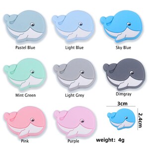 Peut inclure: Neuf breloques en forme de baleine dans les couleurs bleu pastel, bleu clair, bleu ciel, vert menthe, gris clair, gris fonc&eacute;, rose et violet. Chaque breloque mesure environ 3 cm de long et 2,4 cm de large, pour un poids de 4 g.