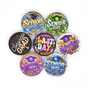 May include: A collection of round graduation-themed buttons. The buttons feature phrases like "Senior 2025", "Congrats Grad", and "Happy Last Day of School". The designs incorporate graduation caps, scrolls, and decorative swirls in various colors.