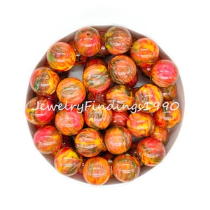 May include: A bowl filled with 20 round, colorful, swirled acrylic beads. The beads are a mix of red, orange, yellow, and green. The beads are about 2 cm in diameter.
