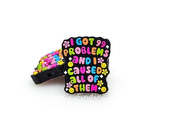 May include: Black charm with the text "I got 99 problems and I caused all of them" in colorful letters with flowers and smiley faces around the text.