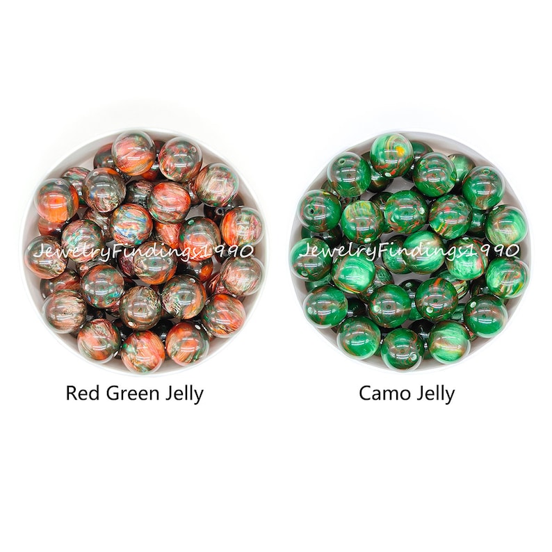 May include: Two bowls of colorful jelly beads. The bowl on the left contains red and green jelly beads. The bowl on the right contains green and brown camo jelly beads.
