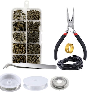 Pode incluir: Um conjunto de suprimentos para fazer joias em um recipiente de pl&aacute;stico transparente com v&aacute;rias pe&ccedil;as de metal douradas, incluindo an&eacute;is de salto, fechos e contas. O conjunto tamb&eacute;m inclui um alicate, um carretel de cord&atilde;o preto e tr&ecirc;s carret&eacute;is de fio transparente.