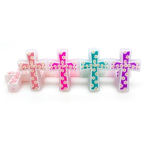 May include: Five colorful cross charms with a white daisy pattern. The crosses are made of a translucent material and have a glittery finish.