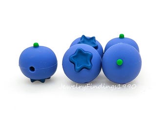 May include: Five blue silicone blueberry shaped beads with green accents. The beads have a star-shaped design on one side.