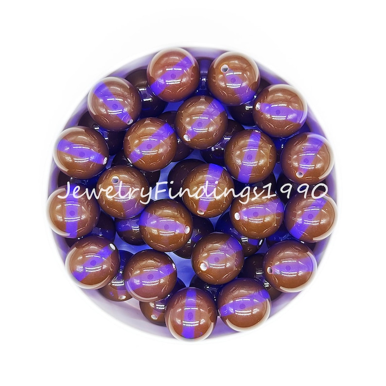 May include: A bowl of brown and purple round beads. The beads have a glossy finish and a purple stripe around the middle.