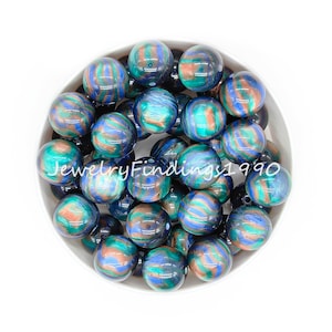 May include: A bowl of blue, green, and brown marbled round beads. The beads have a metallic sheen.