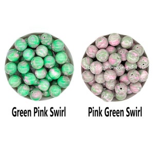 May include: Two bowls of green and pink swirl beads. The bowl on the left has beads that are predominantly green with pink swirls. The bowl on the right has beads that are predominantly pink with green swirls. The text "Green Pink Swirl" is below the left bowl and "Pink Green Swirl" is below the right bowl.
