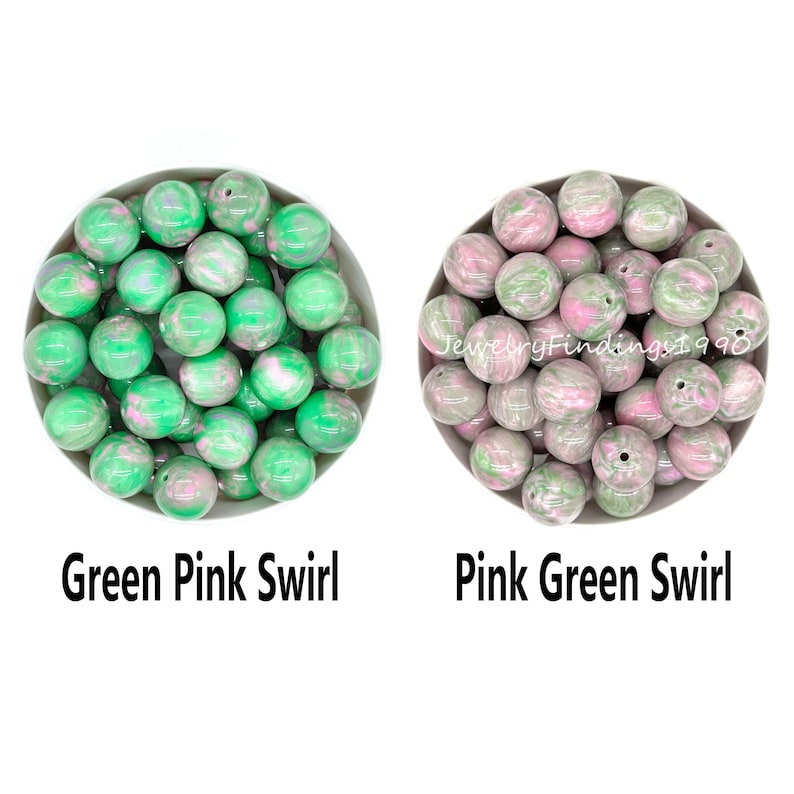 May include: Two bowls of green and pink swirl beads. The bowl on the left has beads that are predominantly green with pink swirls. The bowl on the right has beads that are predominantly pink with green swirls. The text "Green Pink Swirl" is below the left bowl and "Pink Green Swirl" is below the right bowl.