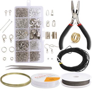 Pode incluir: Um kit de fabrica&ccedil;&atilde;o de joias com uma variedade de achados prateados, incluindo an&eacute;is de salto, fechos, ganchos para brincos e contas. O kit tamb&eacute;m inclui um alicate, um carretel de cord&atilde;o el&aacute;stico preto, um carretel de fio dourado e uma pin&ccedil;a.