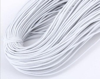 May include: A large spool of white elastic string. The string is tightly wound and appears to be very strong.