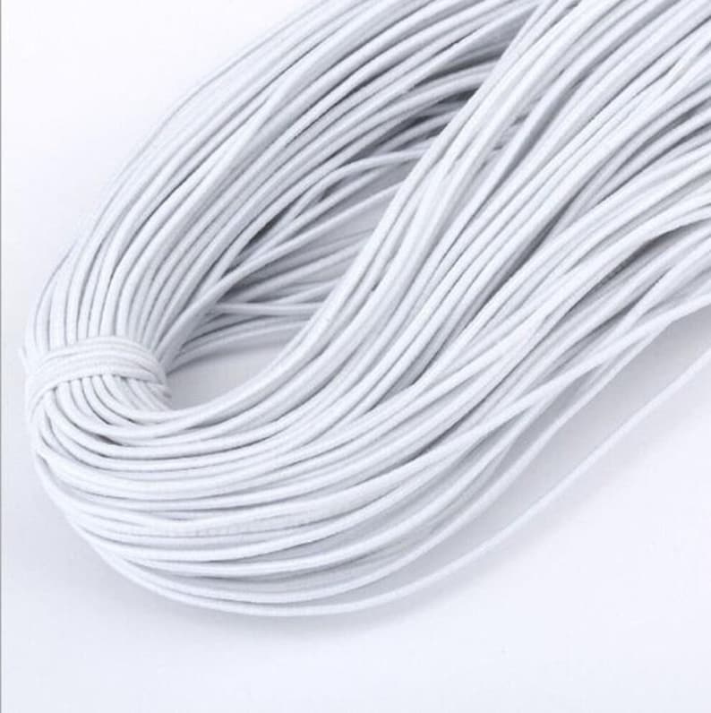 May include: A large spool of white elastic string. The string is tightly wound and appears to be very strong.
