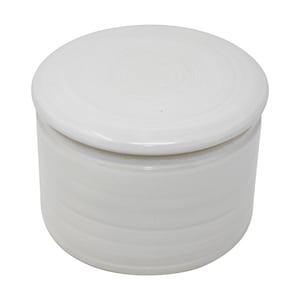 Könnte beinhalten: Weiße Keramik-Butterdose mit Deckel. Die Dose hat eine glatte, abgerundete Form und eine leicht strukturierte Oberfläche.