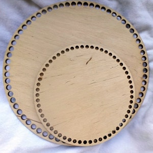 Peut inclure: Deux m&eacute;tiers &agrave; tisser circulaires en bois, l'un plus grand que l'autre, avec des trous autour des bords. Les m&eacute;tiers &agrave; tisser sont de couleur brun clair et ont une finition en bois naturel.