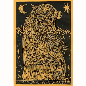 May include: A black and yellow linocut print featuring a bear-like creature standing upright. The artwork includes a crescent moon, a star, and zigzag lines. The bear has textured fur and is set against a black background.