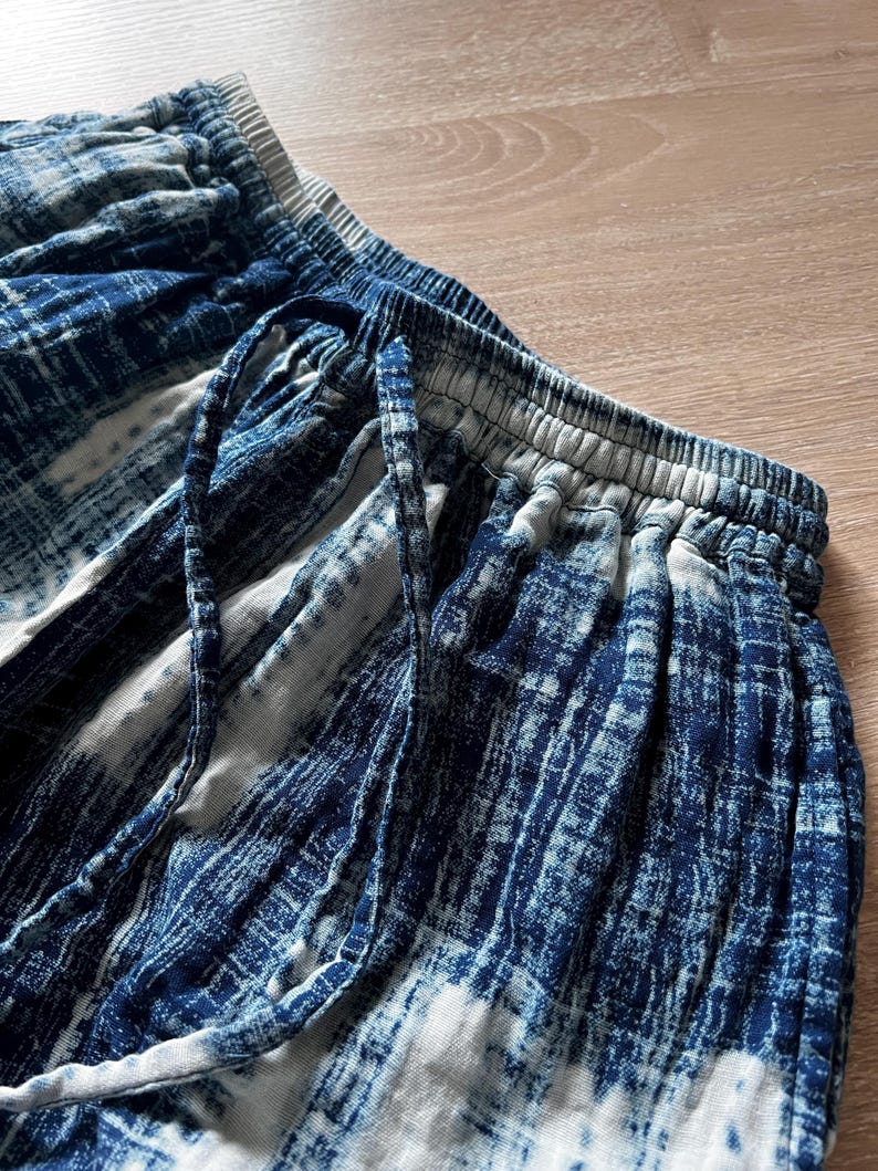 Macro shot of the Still Waters Pants in Ink Shibori, airy double-gauze cotton fabric in indigo, showing weave and hand-dyed variations.
