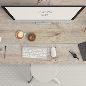 May include: A white desktop computer with a blank screen displaying the text "Your Work Here" is on a wooden desk. The desk also has a white keyboard, a white mouse, a white coffee mug with a brown drink, a brown donut, a white sheet of paper with the text "Your Work Here", a ruler, a pen, a black and gray drawing tablet, a black pen, and a cup of pencils and pens.