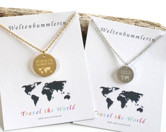 Può includere: Due collane con un ciondolo a forma di mappa del mondo e il testo "Travel the World" su una carta bianca. Le collane sono d'oro e d'argento. Il ciondolo ha le coordinate 47°25'18.1"N 10°59′07.9"O incise su di esso.