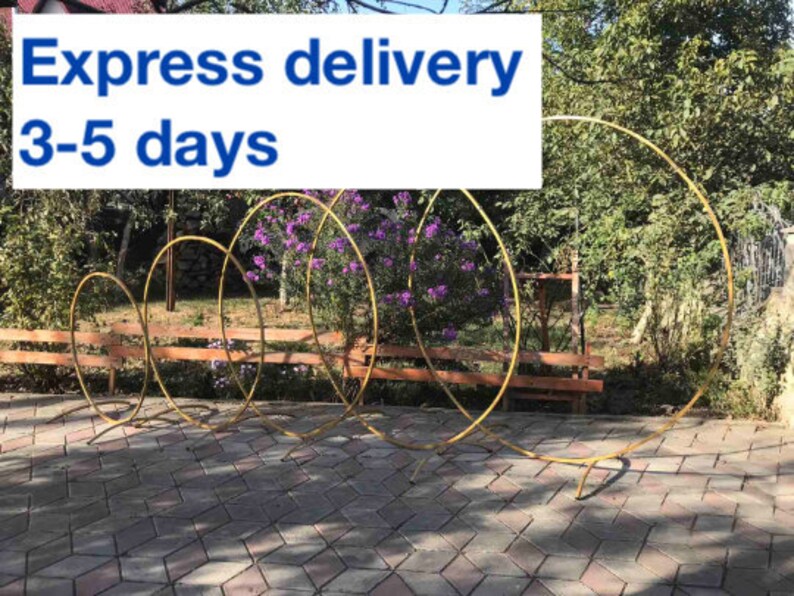 May include: A set of five gold metal hoops arranged in a cascading design. The hoops are used for wedding or event decor. Express delivery 3-5 days.