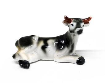 Miniature porcelain figurine of a cow in a recumbent position, 1980s, vintage collectible figurines