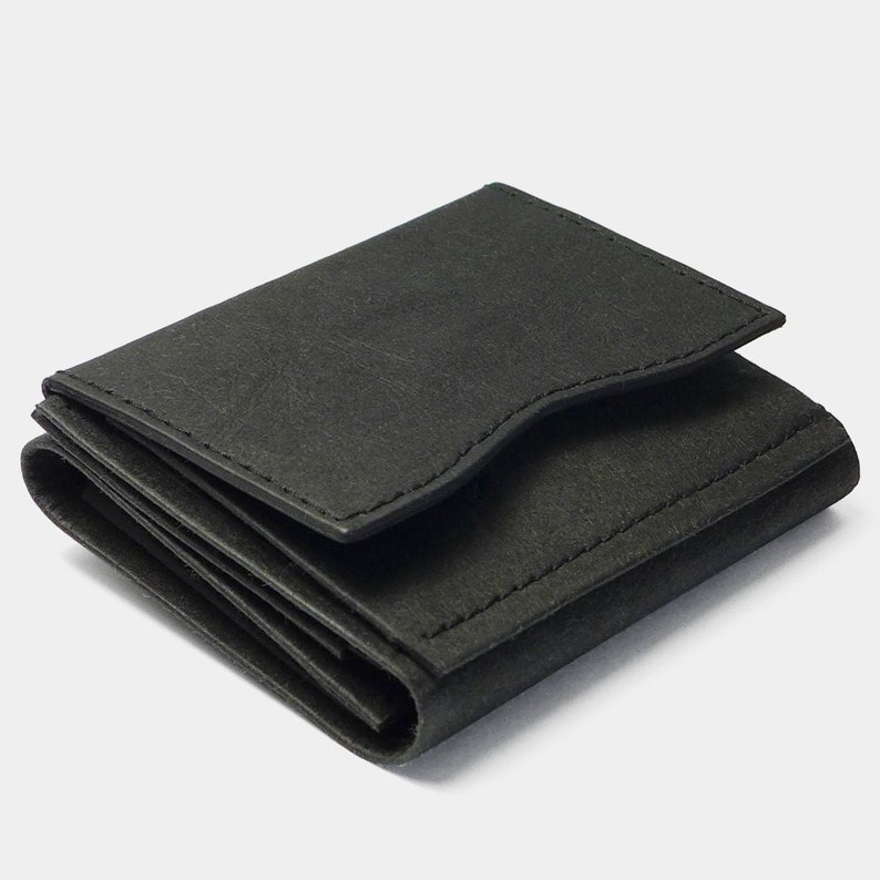 May include: A black leather trifold wallet with a minimalist design.