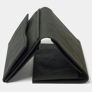May include: A black leather trifold wallet with a textured surface.