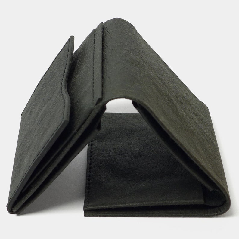 May include: A black leather trifold wallet with a textured surface.