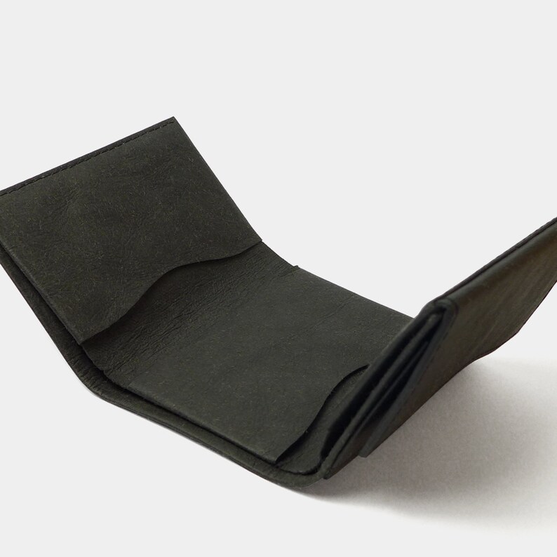 May include: A black leather wallet folded open, revealing the interior with multiple card slots and a billfold.