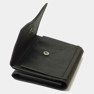 May include: A black leather wallet with a fold-over flap and a snap closure. The wallet is open and has multiple compartments.