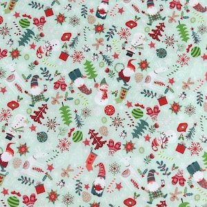 Puede incluir: Una tela verde con un patrón repetitivo de gnomos navideños, árboles, bastones de caramelo, copos de nieve y otros elementos festivos.