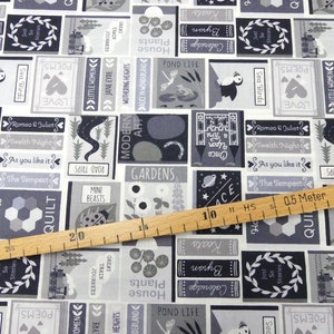 Puede incluir: Una tela blanca con un estampado negro y gris de portadas de libros con varios títulos e ilustraciones. La tela presenta una regla con marcas en pulgadas y medias pulgadas.