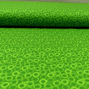 Könnte beinhalten: Grüner Stoff mit einem weißen Kreis-Muster. Der Stoff ist in der Mitte gefaltet.