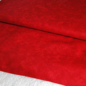 May include: Red fabric with a slightly textured surface. The fabric is folded in half, showing the underside.