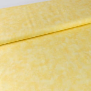 Può includere: Un tessuto piegato con un motivo screziato nei toni del giallo e del crema. Il tessuto ha un aspetto morbido e strutturato, con un sottile effetto acquerello. Il materiale è probabilmente cotone o un tessuto simile.