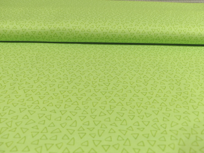 以下が含まれることがあります： 薄い緑色の小さな三角形が繰り返しパターンになっている緑色の生地です