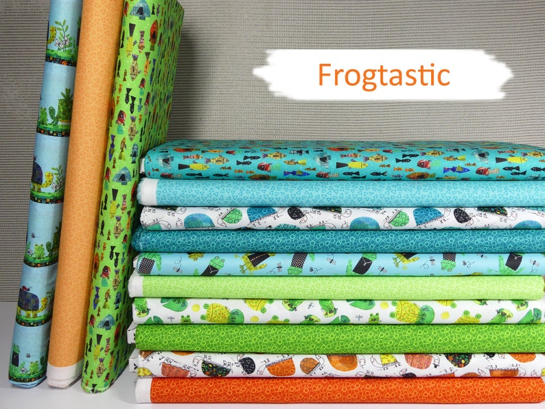 以下が含まれることがあります： カエルをテーマにしたさまざまなパターンが施されたファブリックのスタック。ファブリックは緑、青、オレンジ、白の色合いです。テキスト「Frogtactic」は白い背景にオレンジ色で書かれています。