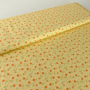 Könnte beinhalten: Gelber Stoff mit einem kleinen floralen Druck mit orangefarbenen Blüten und grünen Blättern.