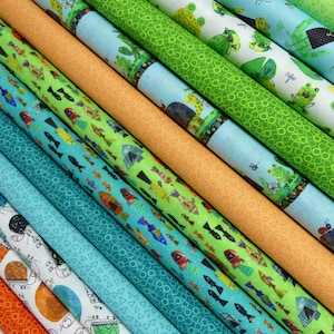 以下が含まれることがあります： 魚、カエル、幾何学模様など、さまざまなパターンが施されたカラフルな生地のロールの集まりです。生地はロール状に巻かれ、一列に並べてあり、鮮やかな色とユニークなプリントが際立っています。