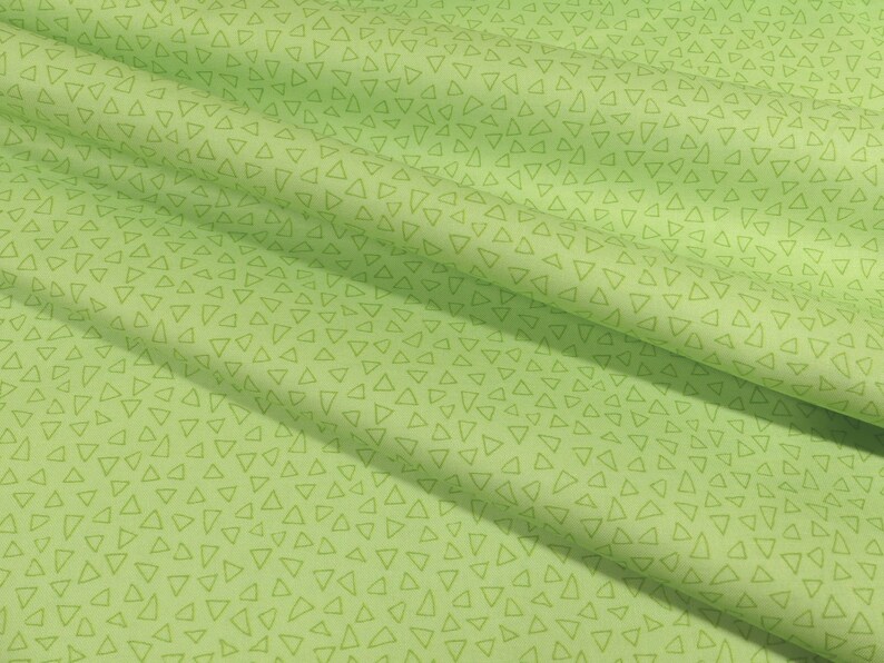 以下が含まれることがあります： 薄い緑色の小さな三角形が繰り返しパターンになっている緑色の布地