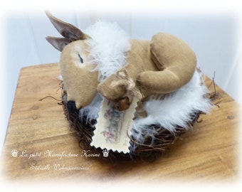 Nostalgic old flour sack Easter decoration sleeping Easter bunny with tulle collar in the Easter basket in shabby chic, vintage, country house style