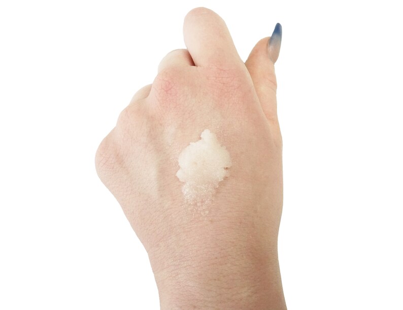 May include: A close-up of a hand with a white, grainy substance on the palm. The substance appears to be a scrub or exfoliant.