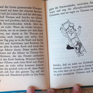 May include: Open book with German text and a black and white illustration of a girl climbing a ladder. The illustration shows the girl wearing a top hat and striped stockings. Pages are yellowed.
