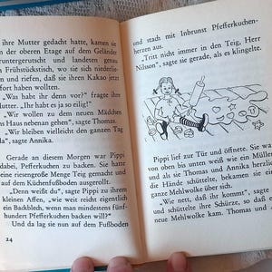 May include: Open book with German text and a black and white illustration of a girl rolling out dough with a rolling pin. The illustration includes hearts and stars. The book is open to pages 24 and 25.