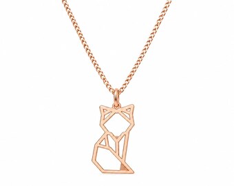 Puede incluir: Un collar de tono oro rosa con una cadena fina y un colgante con forma de gato geométrico estilizado. El colgante está construido con finas líneas metálicas interconectadas que forman el contorno de un gato sentado en un diseño lineal.