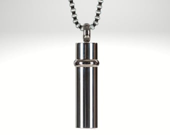 May include: A silver chain necklace with a cylindrical pendant. The pendant has a smooth, polished finish and a subtle band around the middle.