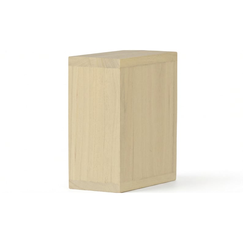 May include: A light-colored, rectangular wooden box with a slightly angled top. The box is made of light-colored wood and has a simple, minimalist design. The box is a solid, rectangular shape.