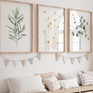 Peut inclure: Un banc de rangement en bois clair avec des bacs blancs, surmonté d'oreillers et d'impressions botaniques encadrées. Une statue de girafe tissée se trouve à proximité. L'art mural présente des illustrations à l'aquarelle de feuilles et de fleurs.