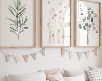 May include: A light wood storage bench with white bins, topped with pillows and framed botanical prints. A woven giraffe statue stands nearby. The wall art features watercolor illustrations of leaves and flowers.