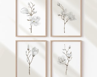 May include: Set of four minimalist watercolor prints featuring white magnolia blossoms on a white background. Each print is framed in a light wood frame.