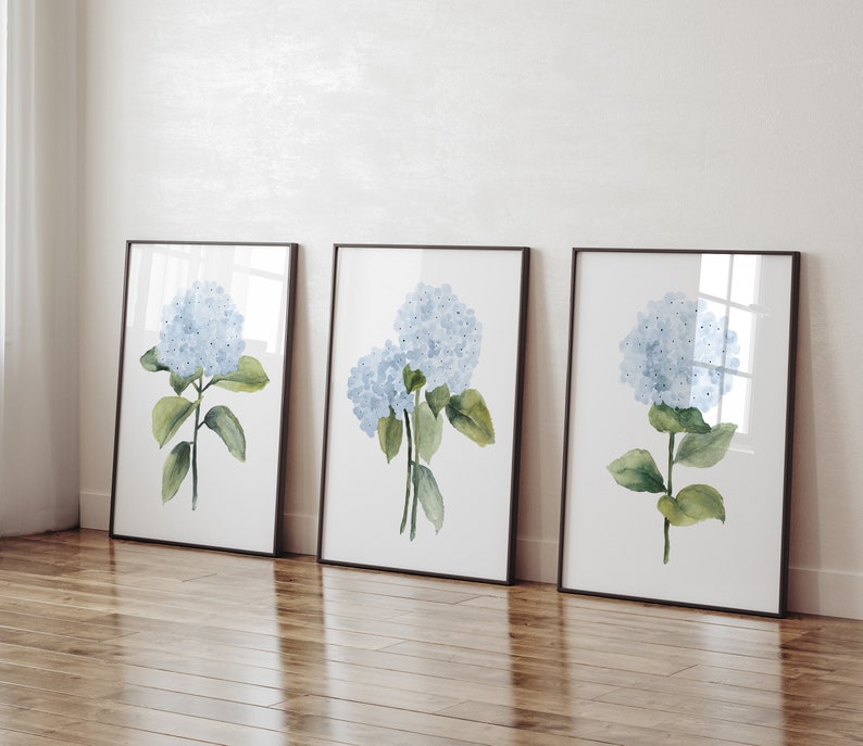 watercolor blue hydrangea set of 3 prints standing on the floor in black frames